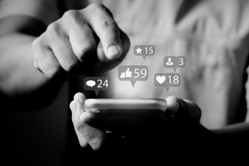Hands holding a phone with social engagement icons