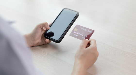 Person holding a phone and credit card while shopping online