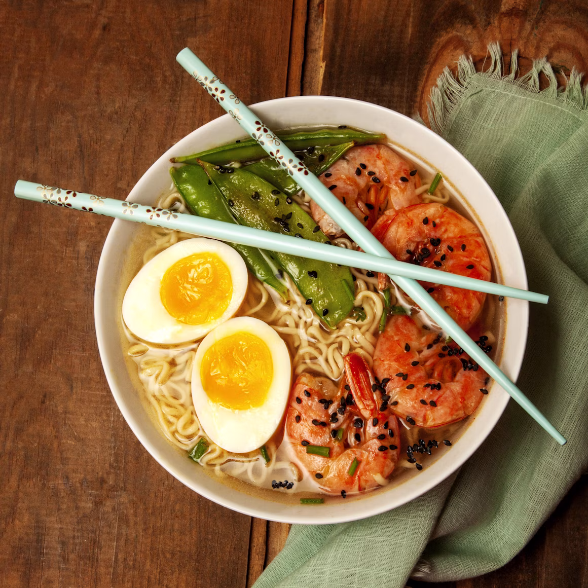 A bowl of ramen with prawns and soft-boiled egg, shot from above