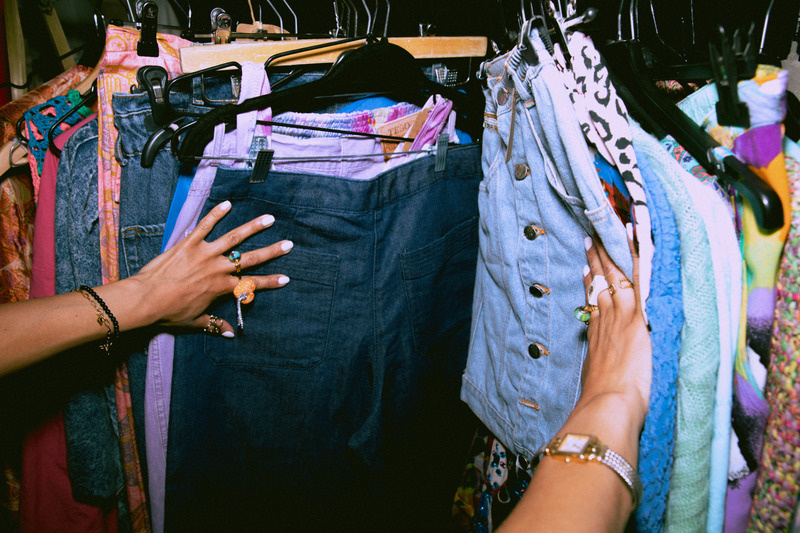 Two people sorting through a rail of denim