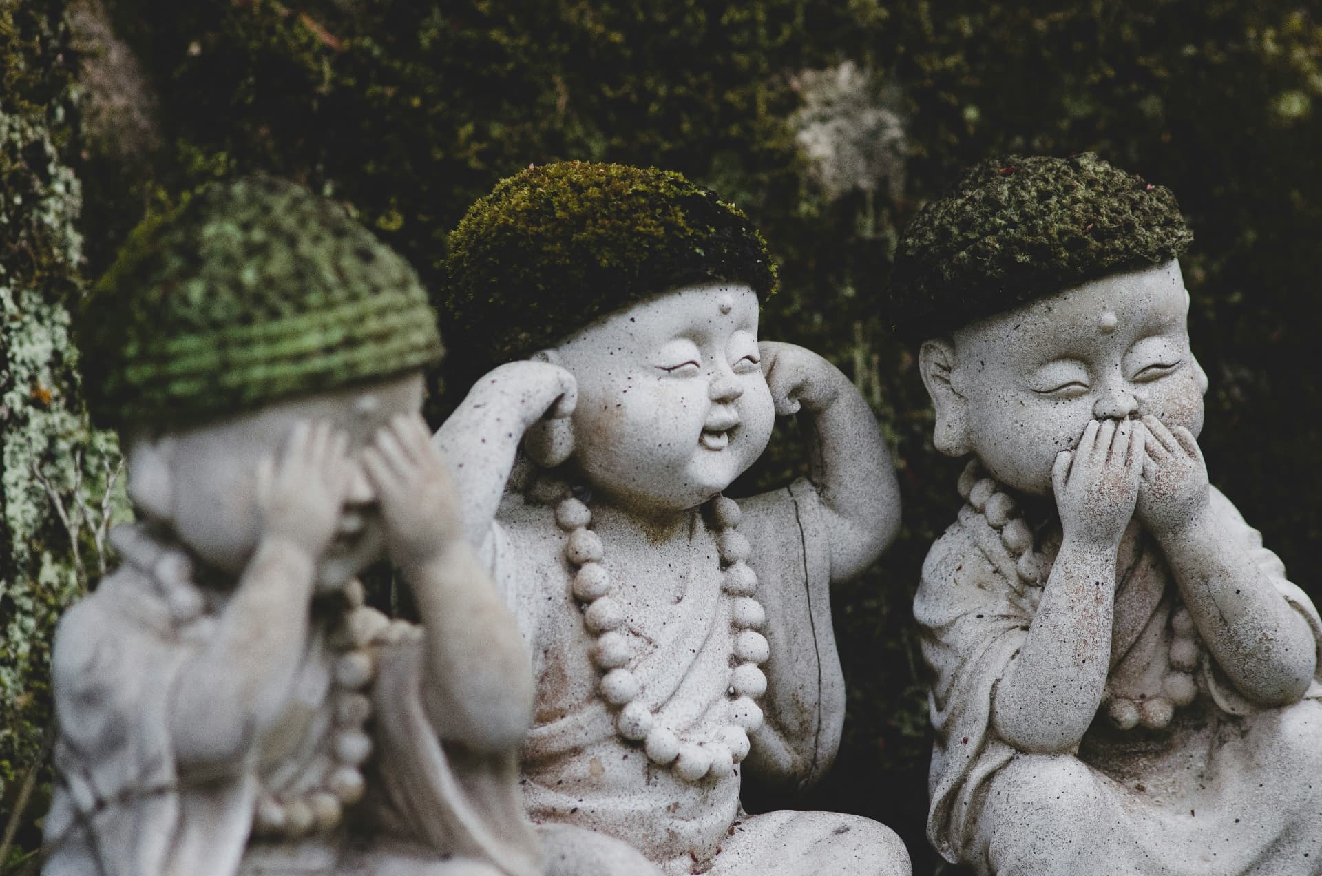 Moss-covered stone statues in a temple garden